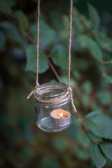 Homemade candle holder hanging on the tree branch, selective focus