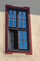 Old window lined with a brown wooden frame. The window is open.