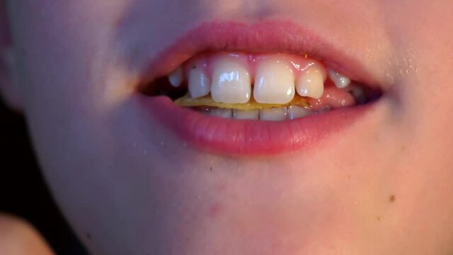 mouth of a teenage boy who eats potato chips with gusto.