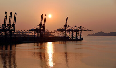 Fototapeta na wymiar Industrial background - sunrise over the sea port with gantry cranes. 