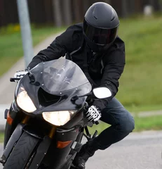 Foto op Plexiglas Handsome motorcyclist in black riding his super sport motorcycle. © Oleg