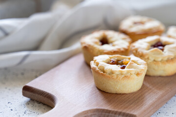 Christmas homemade mince pies on wooden paddle board on white background