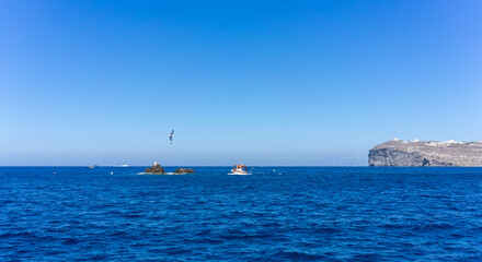 Fototapeta premium Orange and white fishing boat followed by seagulls on aegean sea. blue sky and sunny day