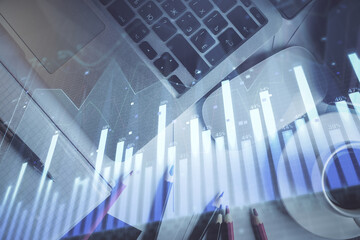 Double exposure of financial chart drawing over table background with computer. Concept of research and analysis. Top view.