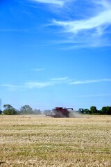 Fototapeta premium A combine is seen harvesting wheat