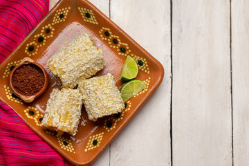 Fototapeta na wymiar Mexican corn on the cob also called elotes with cheese and mayonnaise on white background