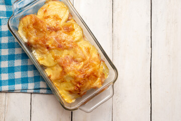 Scalloped potatoes with ham and cheese on white background