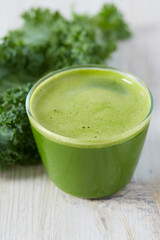 kale juice in a glass on white surface