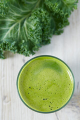 kale juice in a glass on white surface