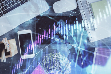 Double exposure of forex chart hologram over desktop with phone. Top view. Mobile trade platform concept.