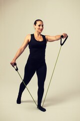 fitness woman with elastic bands doing front shoulder