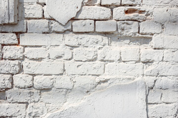 Ancient light blue brick wall with peeling plaster. Texture or background. 
