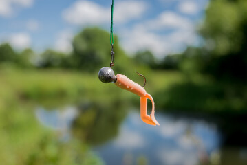 silicone fishing bait/silicone fishing bait on a fishing line against the background of the river