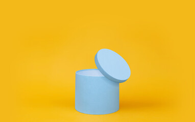 Blue round gift box on yellow background.