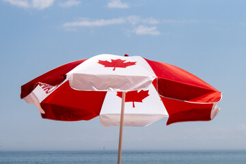 A Canadian maple leaf flag umbrella with the horizon in the distance celebrating Canada Day on the...