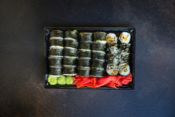 fresh sushi rolls salmon fish flying fish roe vegetables ginger wasabi rice and nori on the table serving size top view place copy space for text food background rustic