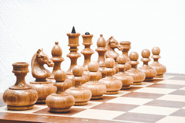 White chess pieces on the board on white background. Start position of chess pieces.