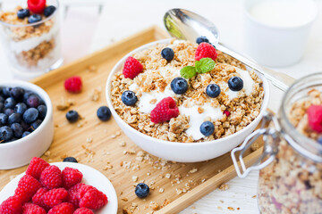 bowl of fresh muesili cereals with curd yogurt and berries on the breakfast table. blurry background for text area.