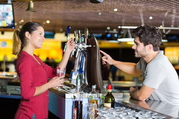 female worker serving a drink to male customer