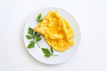 Scrambled eggs on plate over white background. Top view, flat lay