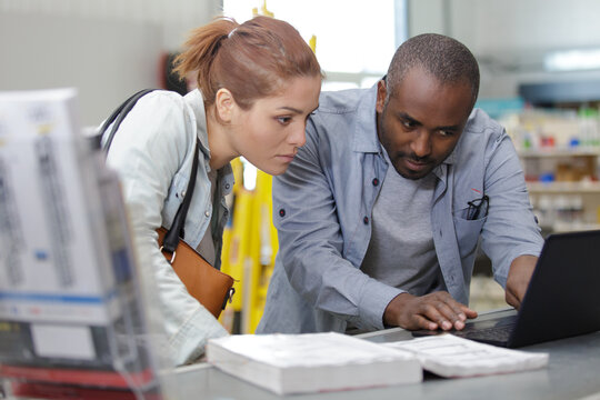 woman with male consultant near the counter with a laptop