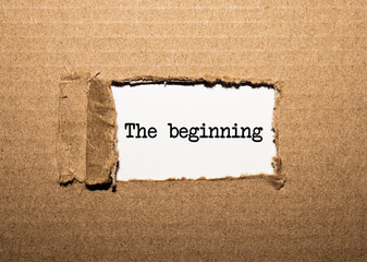 The text THE BEGINNING. behind torn brown paper