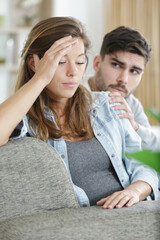 portrait of young sad woman sitting back to her husband