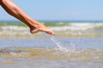 Girl's leg in sea spray. Splashes of clear sea water.