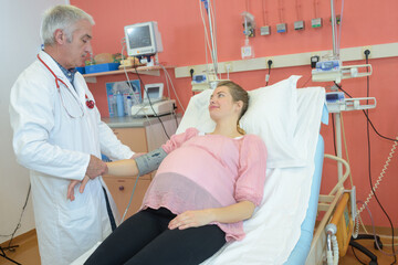 doctor measures the pressure of a pregnant woman