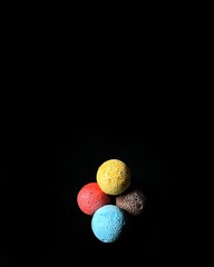 Polystyrene colored balls on black background. decorative concept