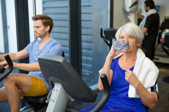 senior woman in gym having a drink of water