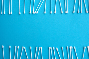 Cotton ear swabs sticks on blue background. close up. Image with selective focus, noise effect and toning. Top view. Flat lay.