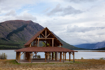 Outdoor public hall in front of a lake with mountains in the background. Taken in Carcross, Yukon, Canada.
