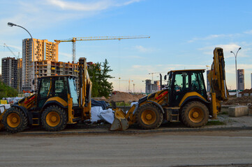 construction machinery builds in the city center. excavators for excavating sand and making foundations. yellow big construction equipment to create a new quarter in the city