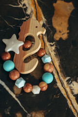 Cute wooden baby toys on the marble background. Animal toys. Eco accessories, beanbag and teethers for newborn. Flat lay, top view