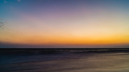 Naklejka na ściany i meble view from the beach on the setting sun