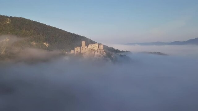 Aerial view of abandoned clifftop Strecno castle over of morning fog, Slovakia.
