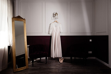 White wedding dress hanging in the bedroom. White bride dress