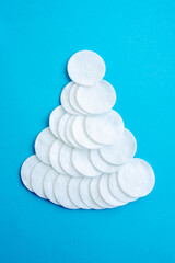 Flat lay composition with cotton pads on blue background. Image with selective focus, noise effect and toning. Top view. Kids Christmas Tree Craft. DIV.