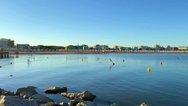 Timelapse of unidentifiable people in the late afternoon on Caorle beach in Veneto, Italy.