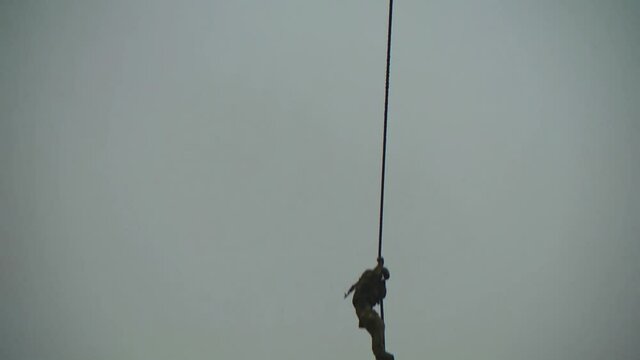 Landing without a parachute from a helicopter. Military paratroopers descend the cable.