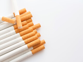 Cigarettes with a yellow filter lie on a white surface