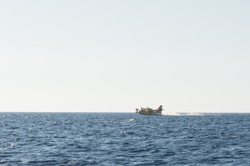 propeller firefighters plane taking water from the sea