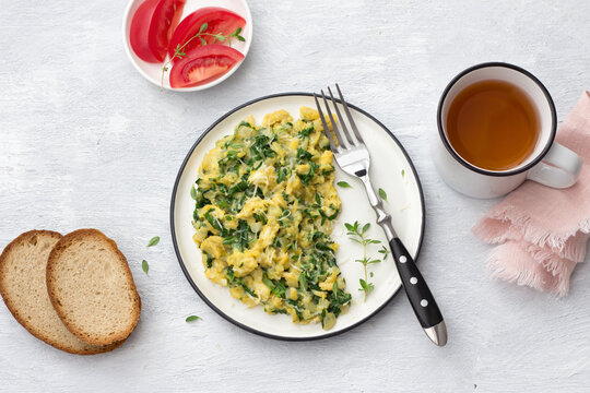 Scrambled eggs with kale and cheese on a light gray background, top view. delicious homemade breakfast