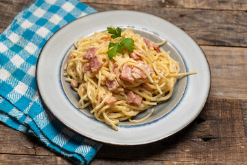 creamy spaghetti pasta with ham on wooden background