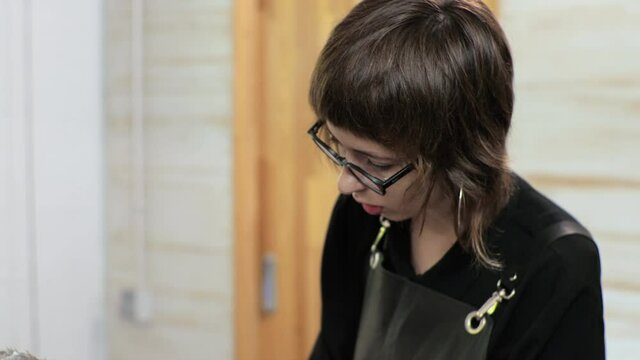Hairdresser cuts short hair with a clipper. Home salon during the epidemic.