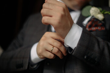 Man in suit straightens shirt sleeve