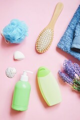 Obraz na płótnie Canvas Blue sponge, green liquid soap package, moisturizing shampoo, wooden hair brush, blue towel and lavender flowers. Flat lay beauty photo