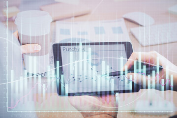 Double exposure of man's hands holding and using a phone and financial chart drawing. Market analysis concept.