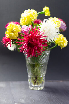 Fresh Colorful Asters Bouquet In Cristal Vase On Black Background